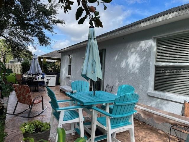 view of patio featuring outdoor dining space and fence