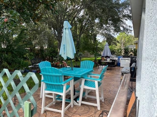 view of patio with outdoor dining space and fence