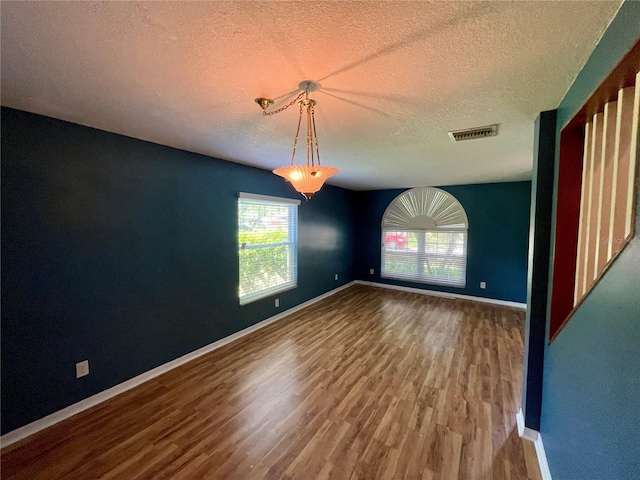 interior space featuring a textured ceiling and wood-type flooring