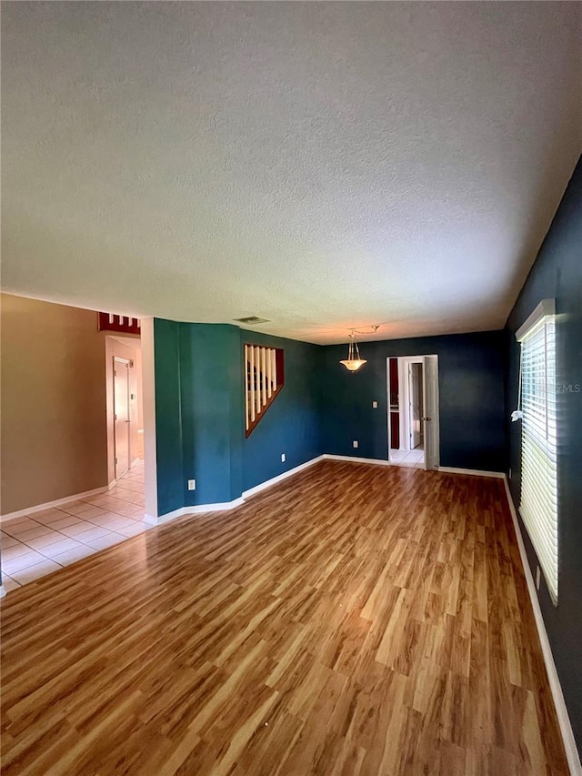 unfurnished living room featuring wood-type flooring and a textured ceiling