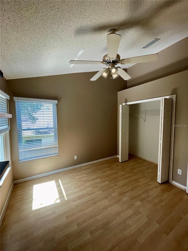 unfurnished bedroom with vaulted ceiling, ceiling fan, a closet, and light hardwood / wood-style floors