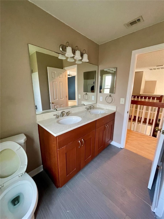 bathroom featuring toilet, hardwood / wood-style floors, and vanity