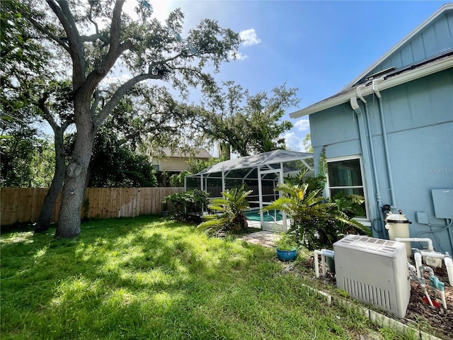 view of yard with glass enclosure and a fenced in pool