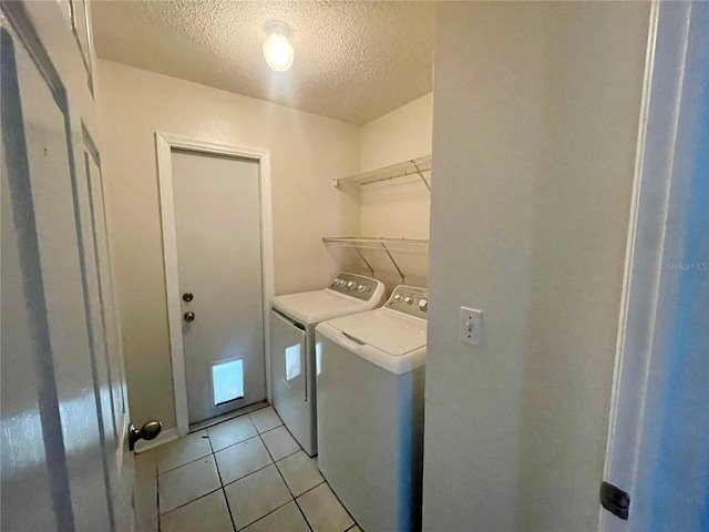 washroom with a textured ceiling, light tile patterned flooring, and independent washer and dryer