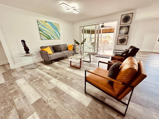 living room with light hardwood / wood-style flooring and ceiling fan