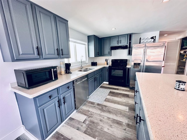 kitchen with sink, light wood-type flooring, and black appliances