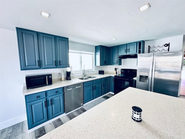 kitchen featuring hardwood / wood-style flooring, black appliances, and blue cabinets