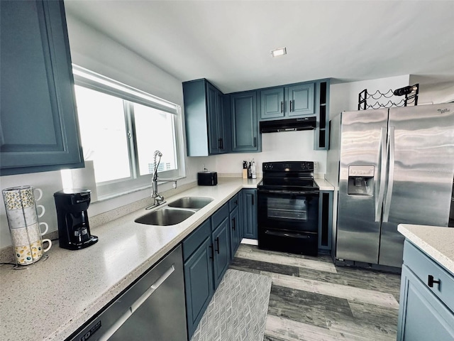 kitchen featuring sink, appliances with stainless steel finishes, light hardwood / wood-style flooring, and blue cabinets