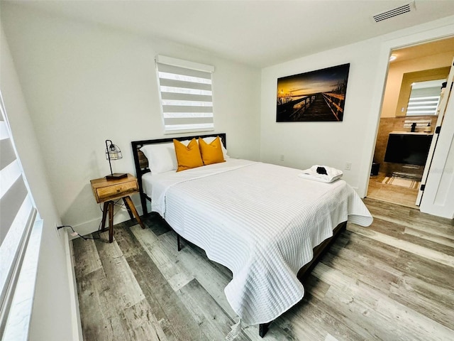 bedroom featuring multiple windows and wood-type flooring