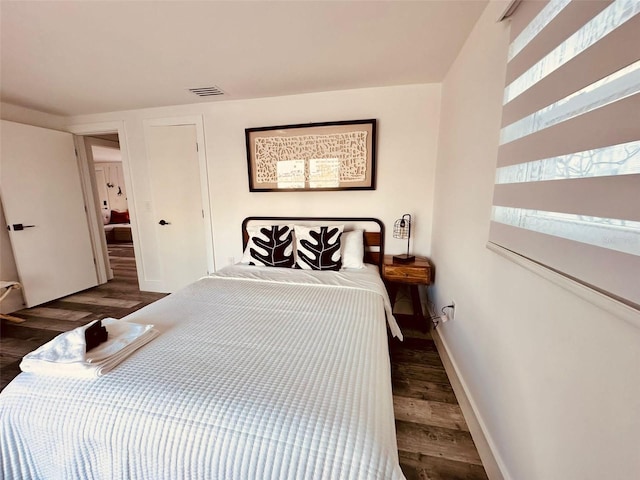 bedroom with dark hardwood / wood-style flooring