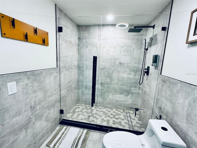 bathroom featuring tiled shower, tile walls, and toilet