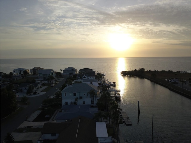 aerial view at dusk featuring a water view