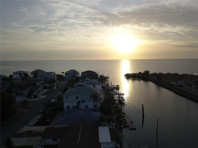 aerial view at dusk featuring a water view