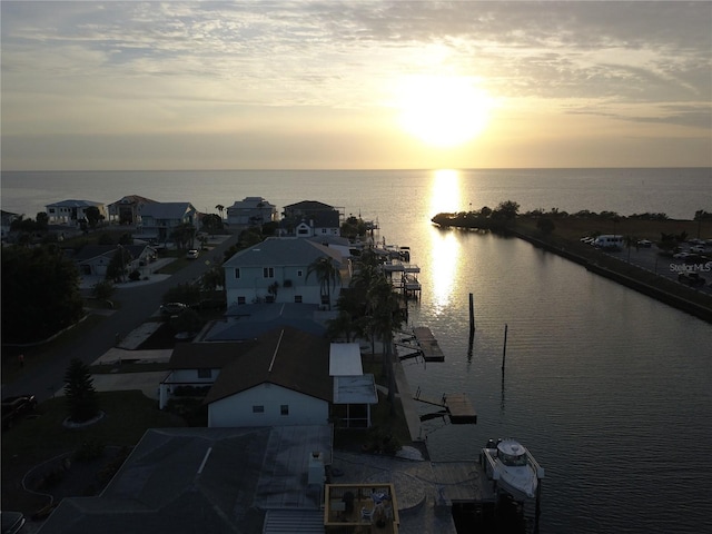 aerial view at dusk featuring a water view