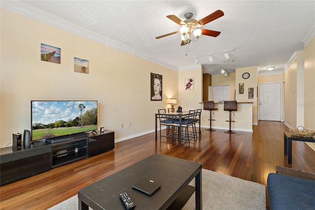 living room with rail lighting, ceiling fan, crown molding, and dark wood-type flooring