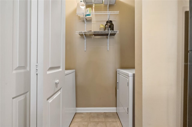 laundry room with light tile patterned floors and washer / dryer