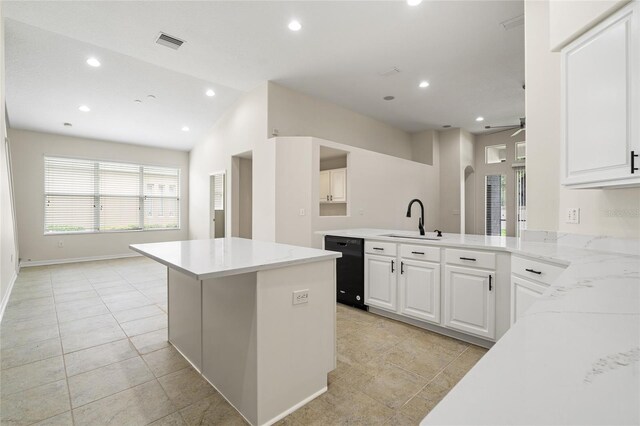 kitchen featuring light tile patterned floors, black dishwasher, sink, and white cabinetry