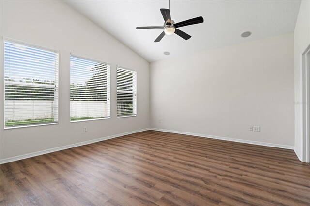 unfurnished room with a wealth of natural light, dark wood-type flooring, and lofted ceiling