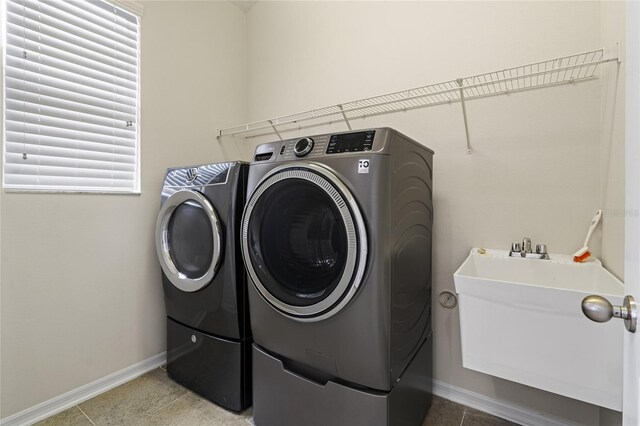 laundry room with light tile patterned flooring and washing machine and clothes dryer