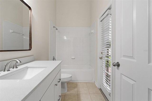 full bathroom with tiled shower / bath combo, tile patterned flooring, toilet, and vanity