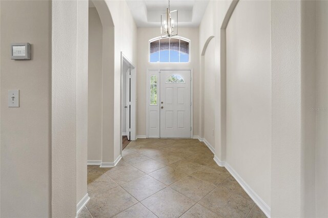 tiled foyer with a towering ceiling