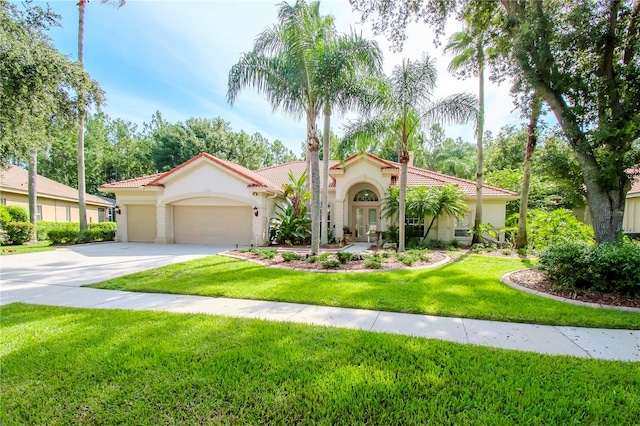 mediterranean / spanish-style home featuring a garage and a front yard