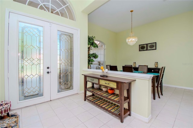 foyer entrance featuring an inviting chandelier, french doors, and light tile patterned floors