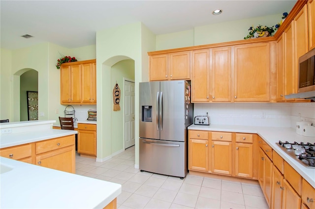 kitchen featuring light tile patterned floors, backsplash, and stainless steel appliances