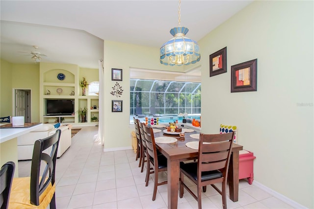 tiled dining room featuring built in features and ceiling fan with notable chandelier