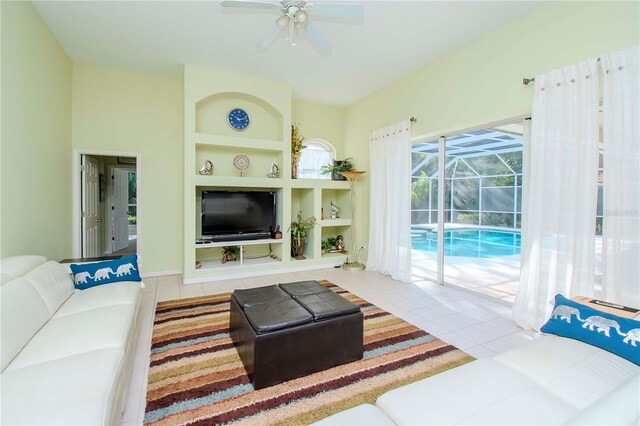 tiled living room featuring built in shelves and ceiling fan