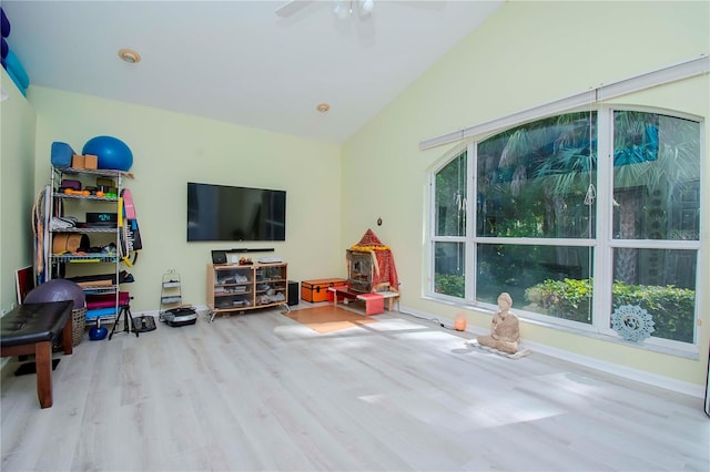 recreation room with vaulted ceiling, ceiling fan, and light wood-type flooring