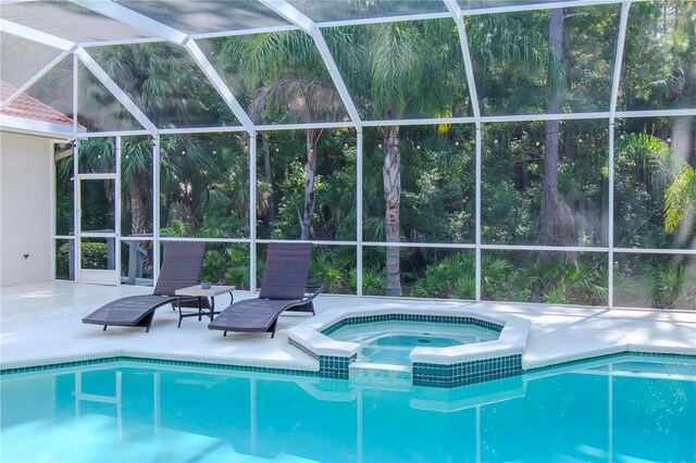 view of pool featuring an in ground hot tub, a patio, and glass enclosure