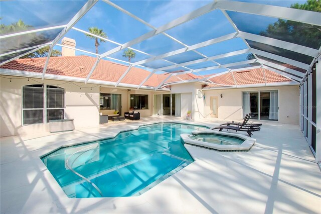 view of swimming pool featuring a patio area, an in ground hot tub, and glass enclosure