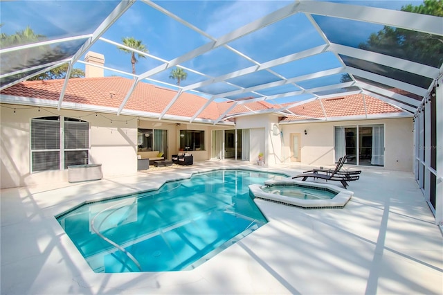 view of pool featuring an in ground hot tub, a patio area, and glass enclosure