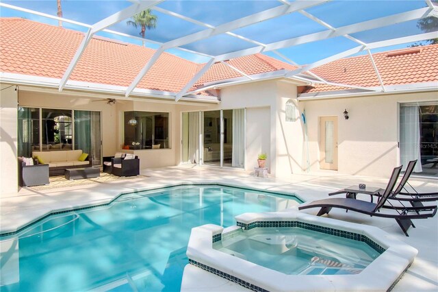 view of swimming pool featuring an in ground hot tub, a lanai, outdoor lounge area, and ceiling fan