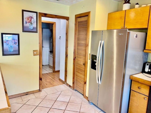 kitchen with stainless steel fridge with ice dispenser and light hardwood / wood-style floors