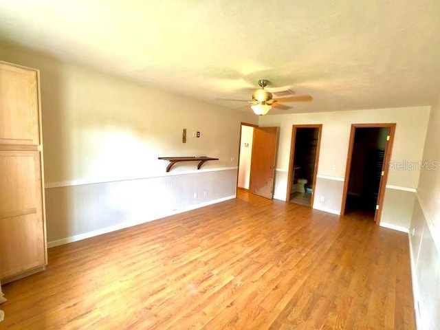 unfurnished bedroom featuring ceiling fan, light hardwood / wood-style floors, and a spacious closet