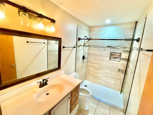 bathroom featuring tile patterned floors, toilet, a tile shower, and vanity