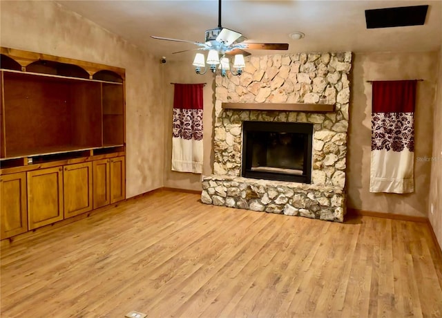 unfurnished living room featuring ceiling fan, light hardwood / wood-style floors, a stone fireplace, and lofted ceiling