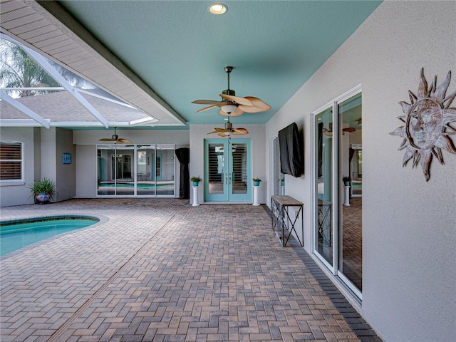 view of pool with a patio area, french doors, glass enclosure, and ceiling fan