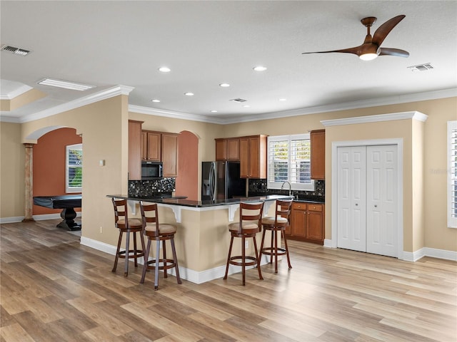 kitchen with pool table, light hardwood / wood-style flooring, ornamental molding, a breakfast bar, and refrigerator with ice dispenser