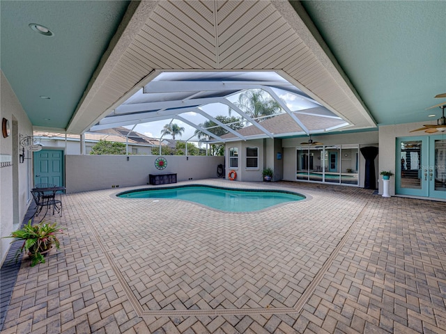 view of swimming pool featuring ceiling fan, a lanai, and a patio area