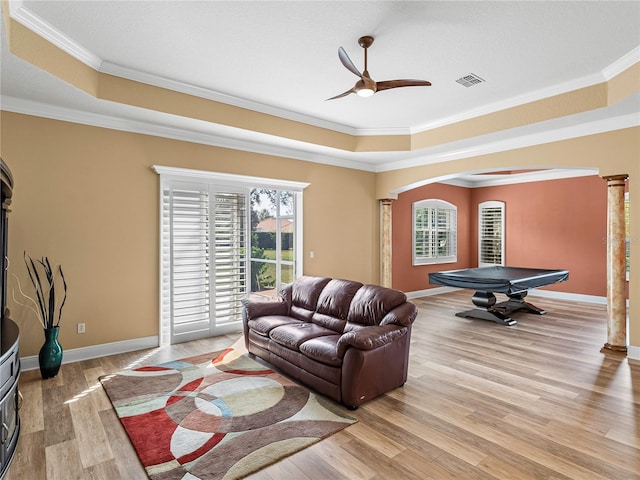 living room featuring decorative columns, light hardwood / wood-style floors, and ornamental molding