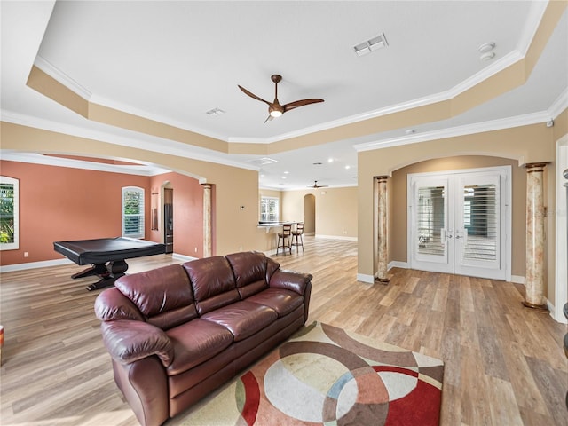 living room featuring ornate columns, ornamental molding, and light hardwood / wood-style flooring