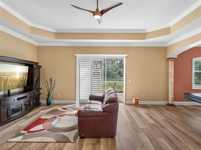 living room featuring ornamental molding, decorative columns, light wood-type flooring, and ceiling fan