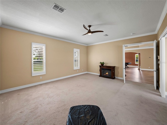 sitting room featuring crown molding, a textured ceiling, light colored carpet, and ceiling fan