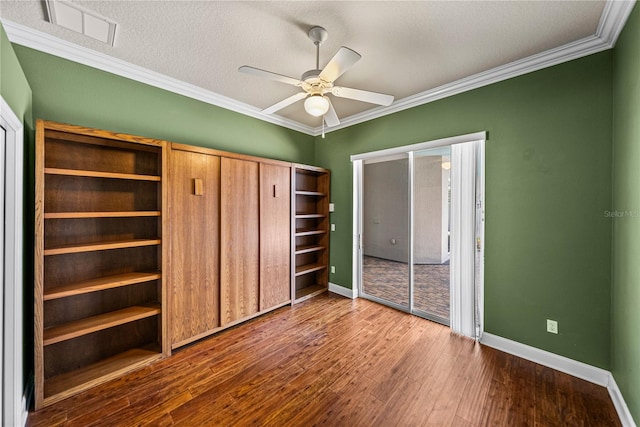 unfurnished bedroom featuring ornamental molding, a textured ceiling, hardwood / wood-style flooring, and ceiling fan