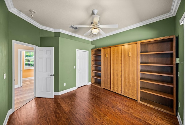 unfurnished bedroom featuring crown molding, dark hardwood / wood-style floors, a textured ceiling, and ceiling fan