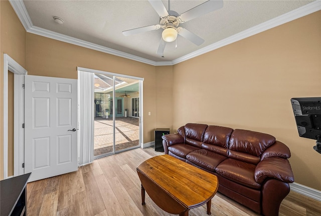 living room with crown molding, a textured ceiling, light wood-type flooring, and ceiling fan