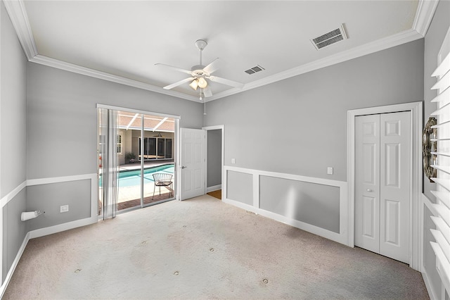 spare room featuring light carpet, ornamental molding, and ceiling fan